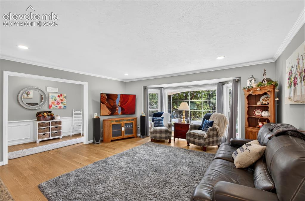 Image 12 of 43: Expansive living area featuring a large bay window, recessed lighting, crow