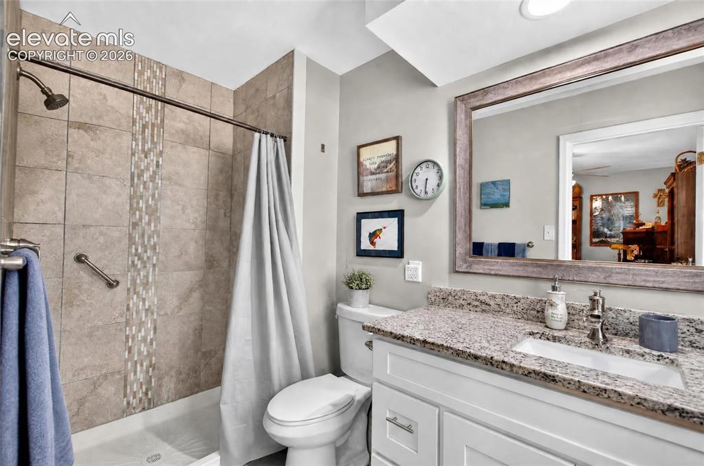Image 16 of 43: Bathtub with subway tile surround, decorative tile inlay, and grab bar