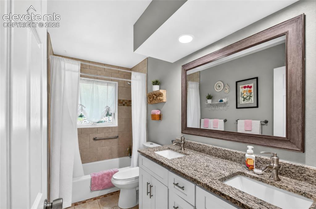 Image 17 of 43: Bathroom featuring a dual vanity with granite countertops, undermount sinks