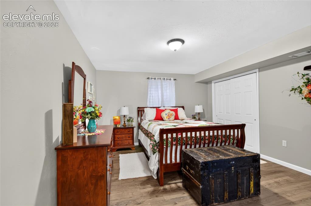 Image 25 of 43: Wood-finish flooring, neutral wall tones, and a built-in closet with bi-fol