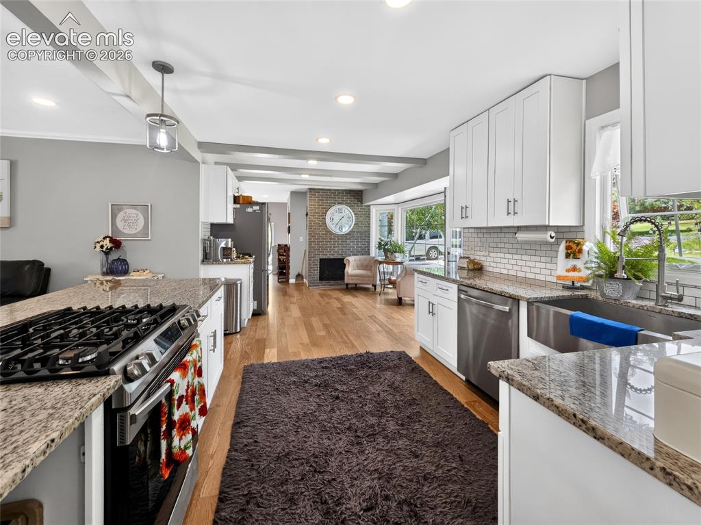 Image 5 of 43: Kitchen featuring a gas range, stainless steel appliances, granite countert