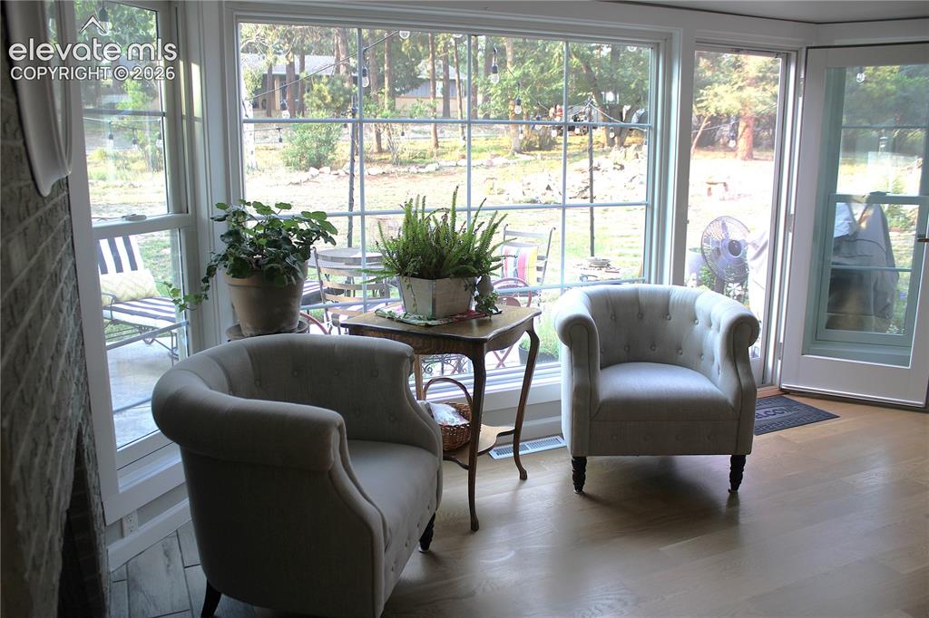 Image 9 of 43: Hardwood flooring, expansive window, transom window, glass-paneled door, br