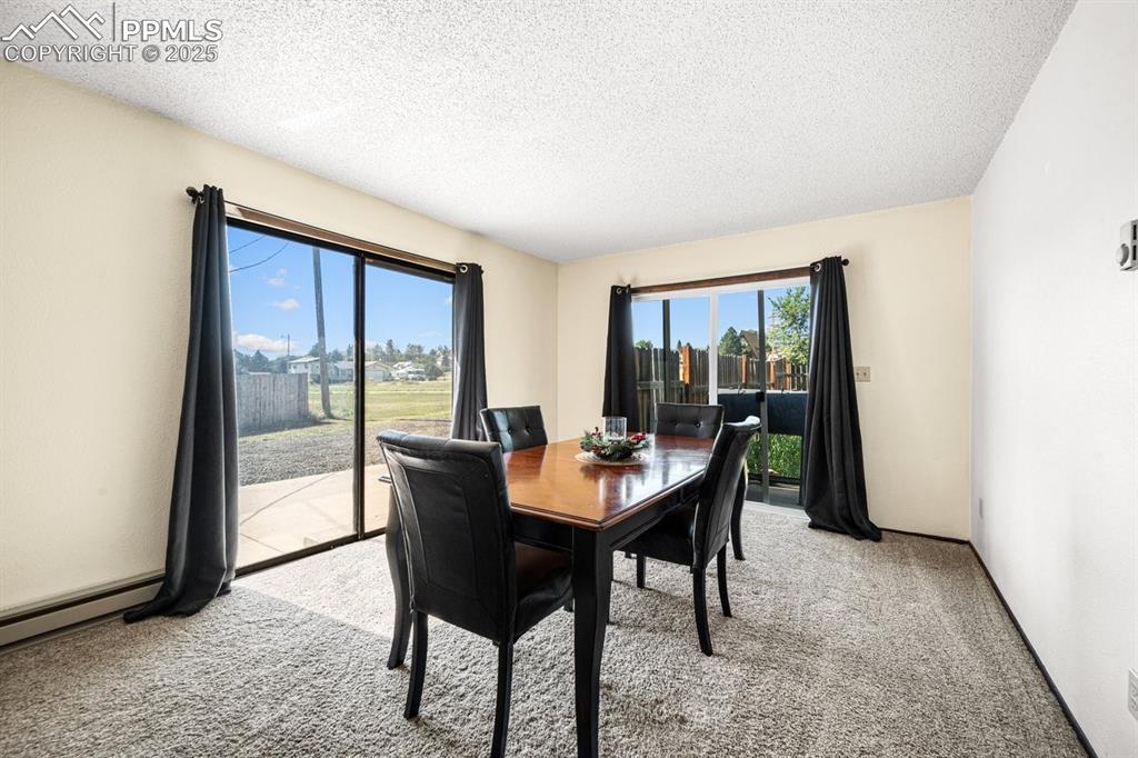 Image 13 of 38: Dining area featuring light colored carpet and a textured ceiling