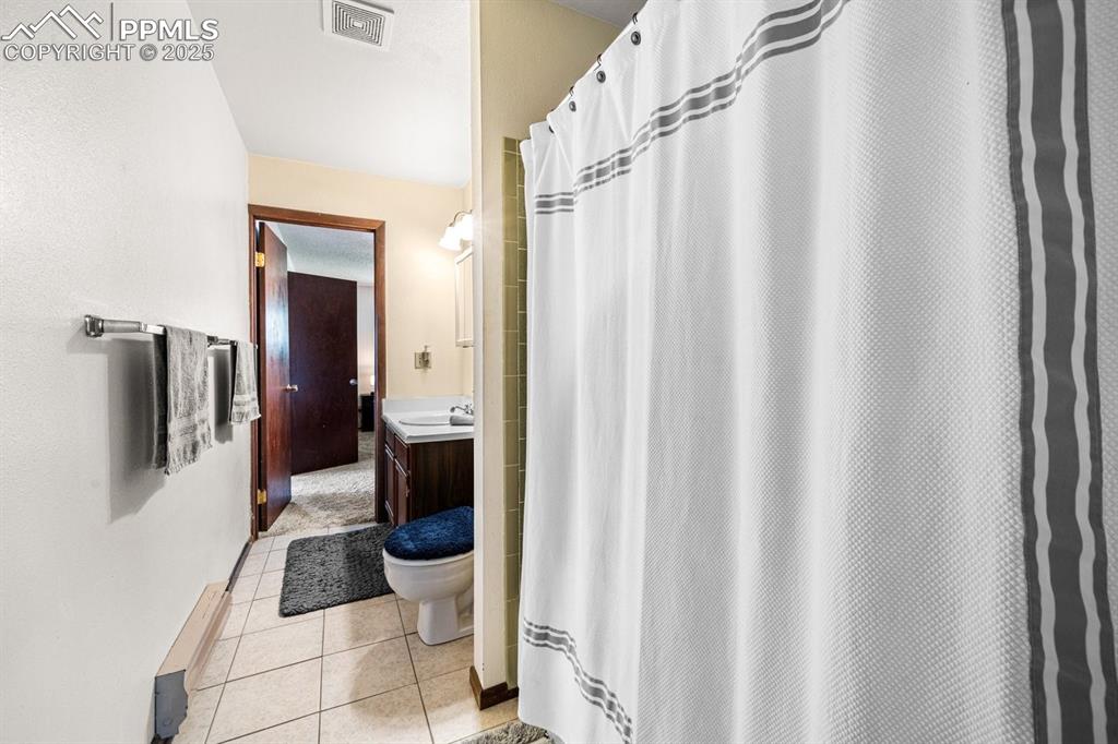 Image 19 of 38: Bathroom featuring light tile patterned floors, vanity, and a stall shower