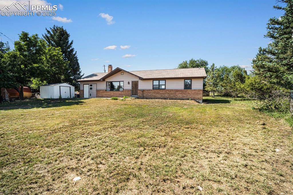Image 2 of 38: View of front of house with a storage unit, a front yard, and a chimney