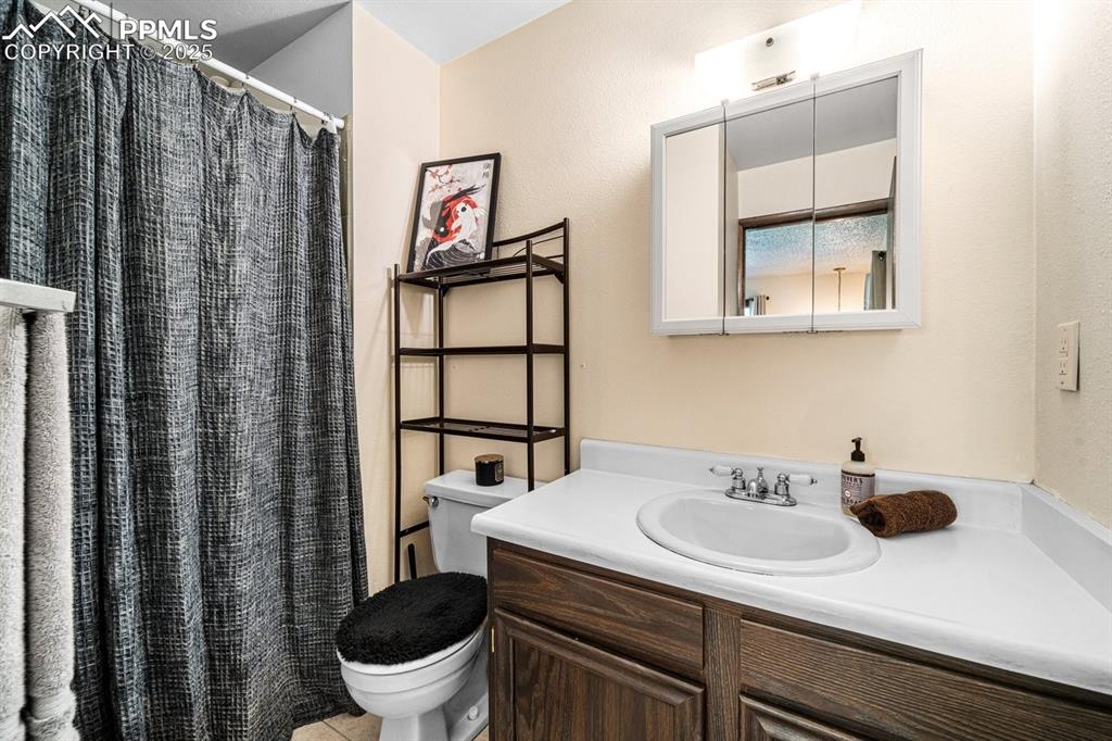 Image 23 of 38: Bathroom with vanity and curtained shower