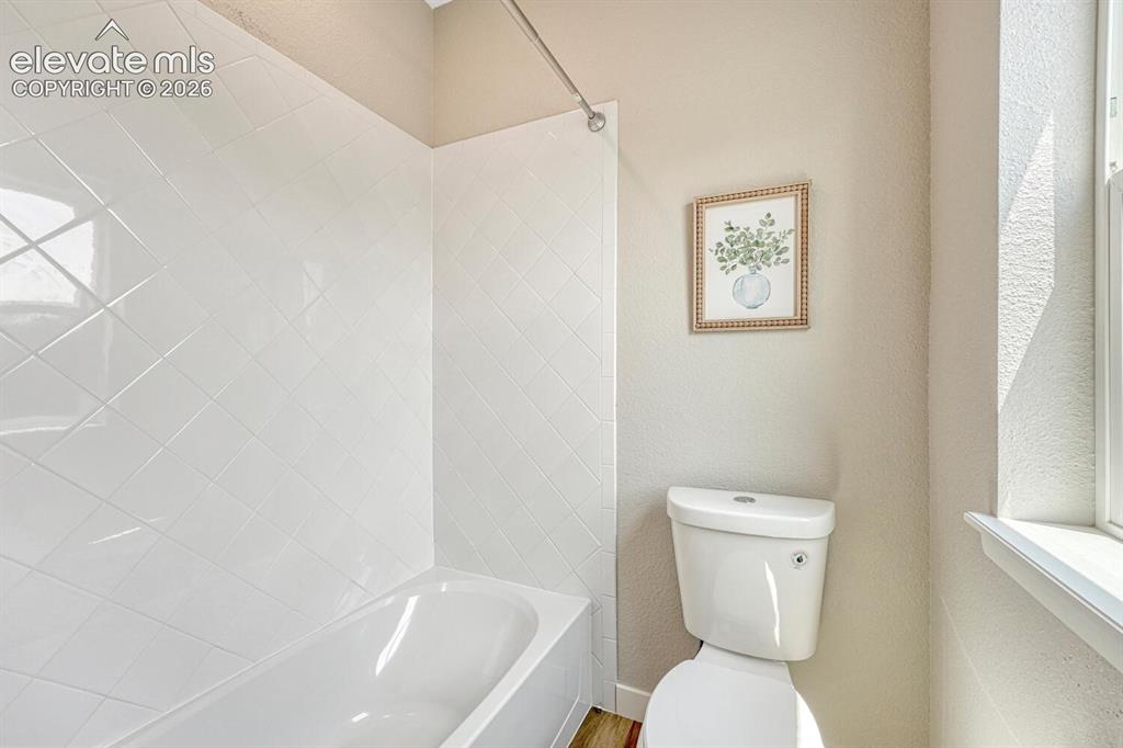 Image 12 of 28: Custom tiled shower tub in the primary bathroom.
