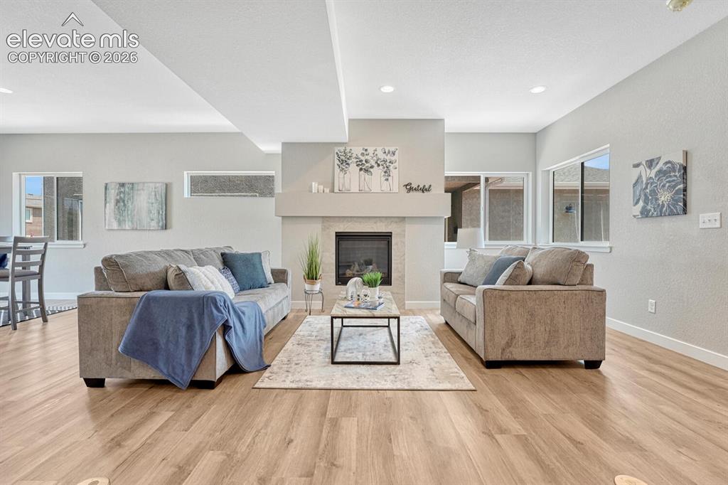 Image 4 of 28: Open living area with gas fireplace