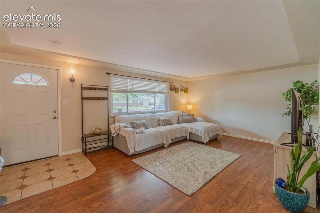 Image 11 of 46: Spacious living area featuring rich wood-finish flooring, a large picture w