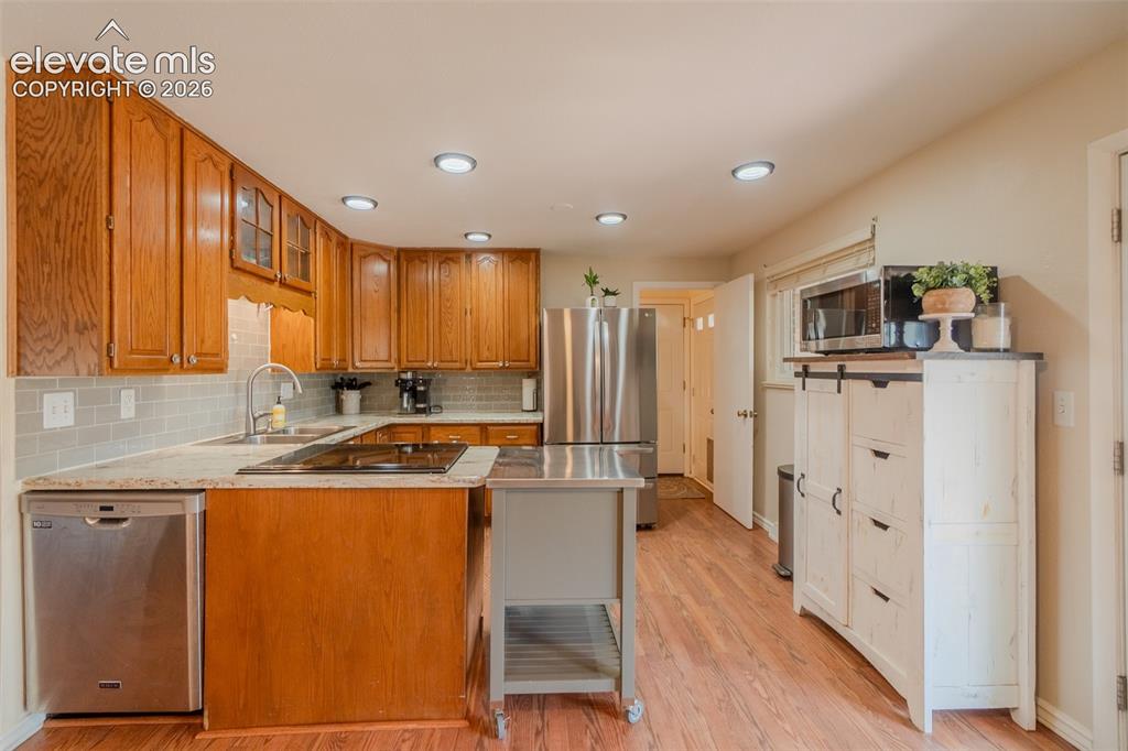 Image 15 of 46: Kitchen featuring wood-finish flooring, recessed lighting, and a subway til