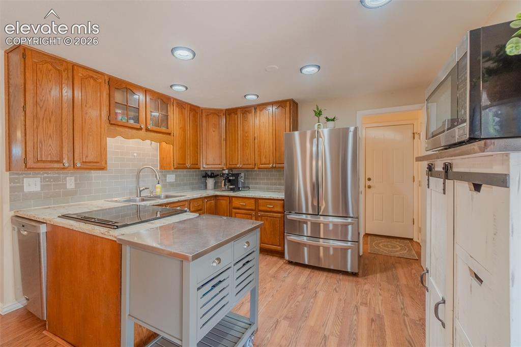 Image 16 of 46: Well-appointed kitchen featuring wood-finish cabinetry, light-toned counter
