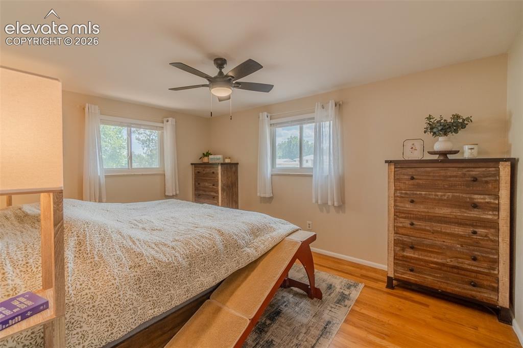 Image 23 of 46: Spacious room featuring a ceiling fan with integrated lighting, wood-finish
