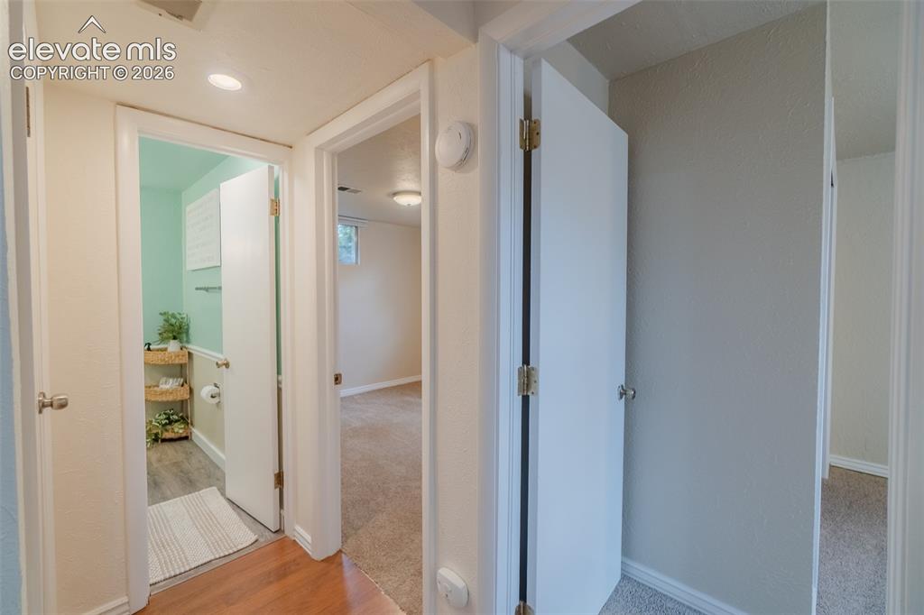 Image 24 of 46: Light-filled bedroom featuring two windows, a ceiling fan with integrated l