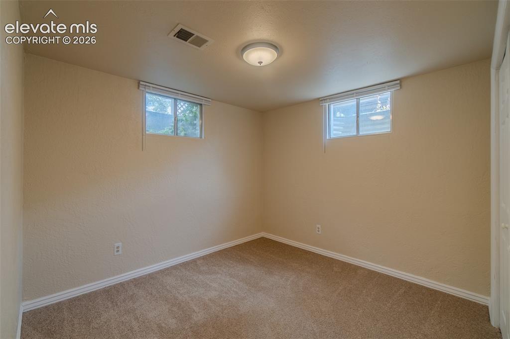 Image 29 of 46: Carpeted room featuring a white door, sliding closet doors with paneled det
