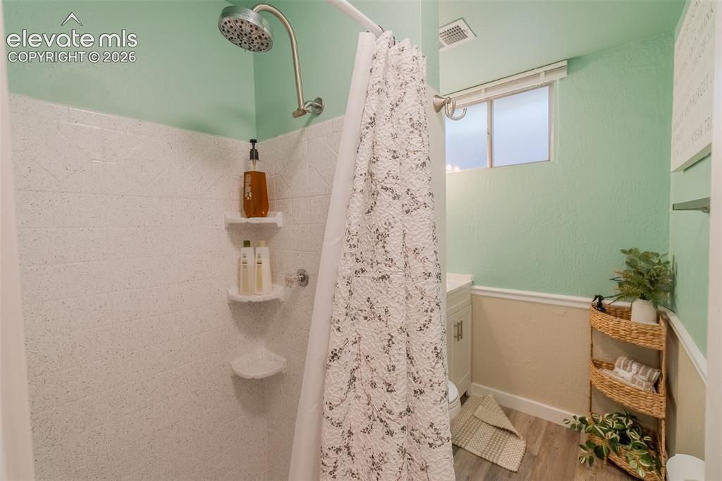 Image 31 of 46: Bathroom featuring a white vanity with integrated sink, chrome faucet, and