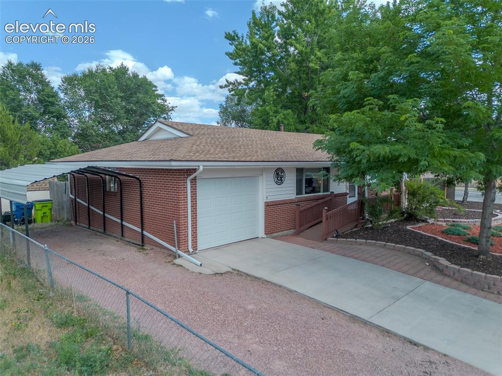 Image 7 of 46: Landscaped front yard featuring decorative rock and mature trees!