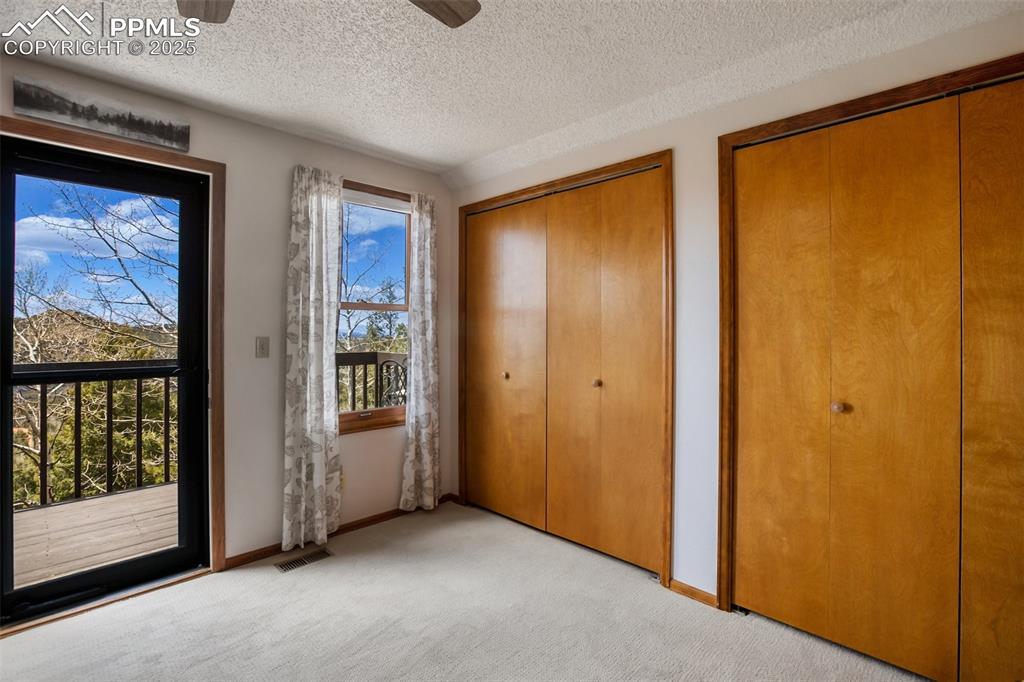 Image 21 of 49: Primary bedroom has a deck with spectacular views