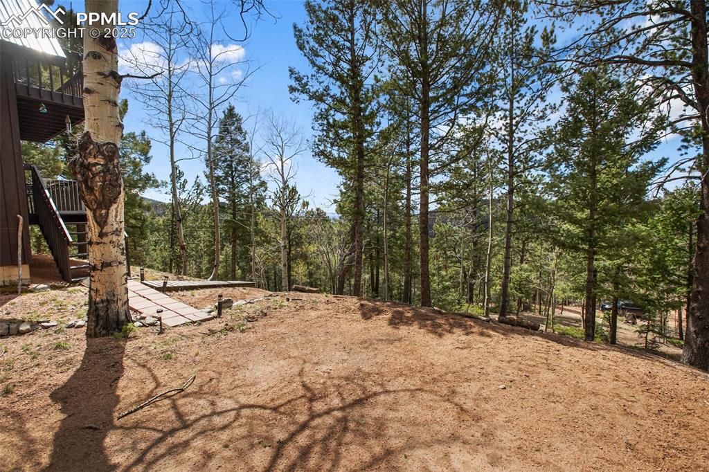 Image 30 of 49: View of yard featuring a forest view