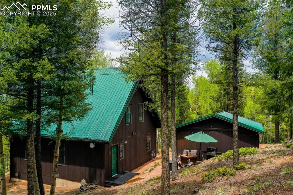 Image 46 of 49: View of side of property featuring metal roof