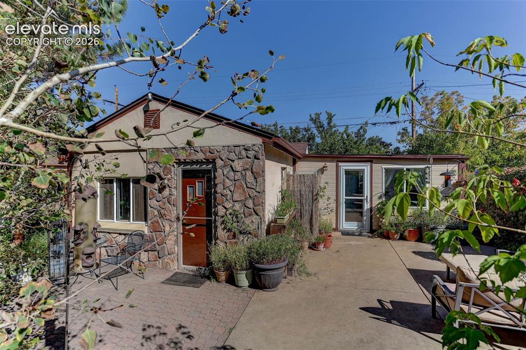 Image 1 of 25: Stone veneer exterior with stucco accents, gabled roofline, and a paved pat