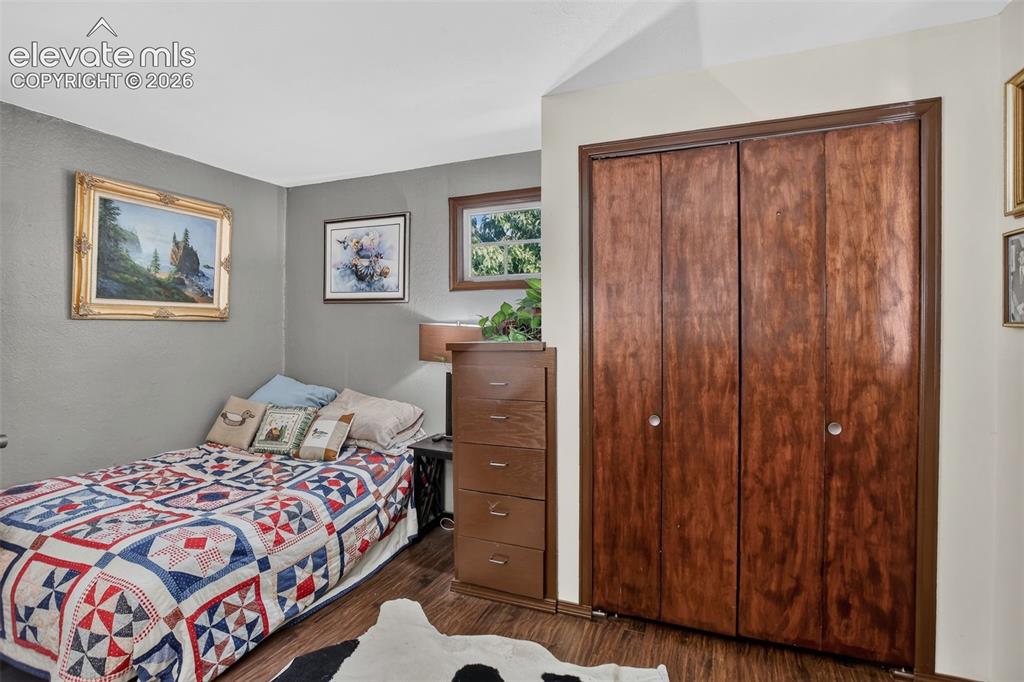Image 19 of 25: Wood-finish flooring with a bi-fold closet, and a framed window