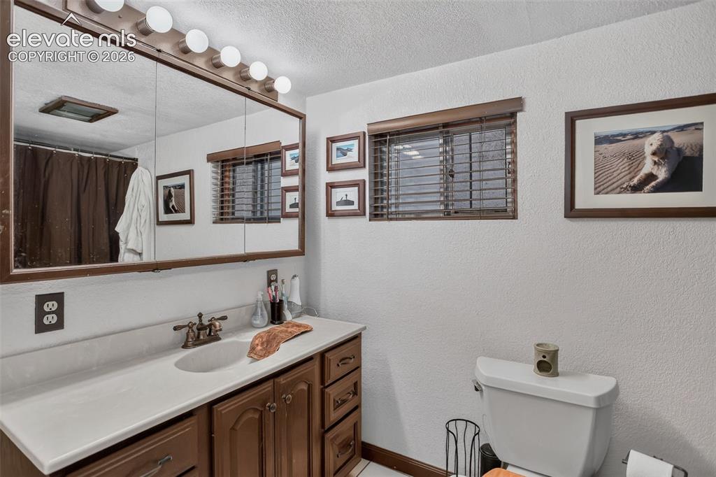 Image 21 of 25: Vanity with built-in storage, integrated sink, and wall-mounted lighting