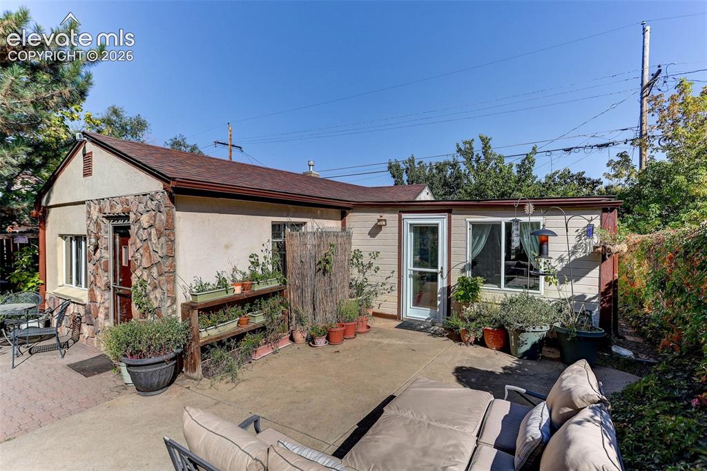 Image 5 of 25: Exterior showcasing a concrete patio, a stone accent wall, and a side door 