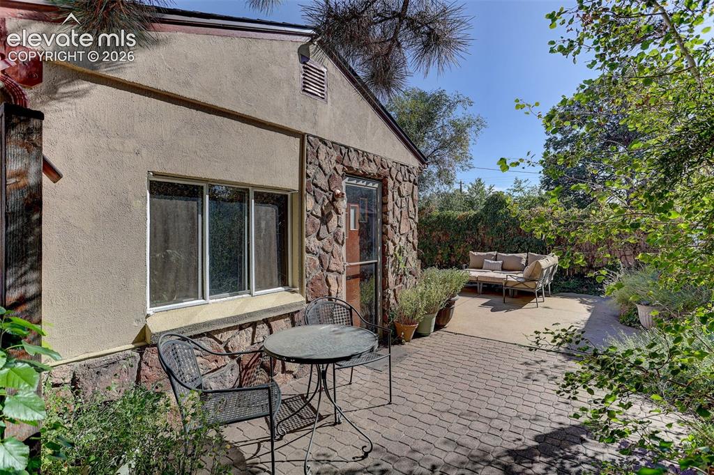 Image 6 of 25: Stucco and stone exterior with multi-pane windows