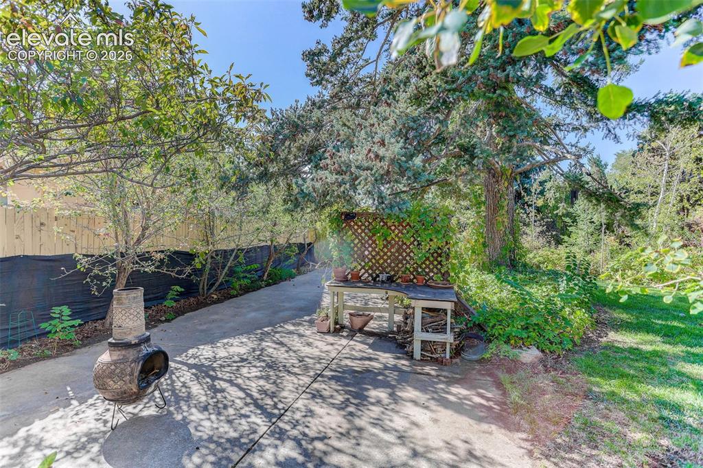 Image 9 of 25: Concrete pathway with a wooden fence