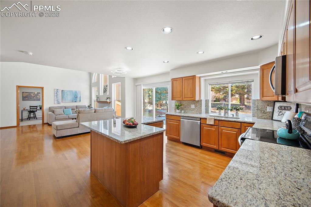 Image 10 of 44: Open concept. Kitchen features granite, new SS appliances, island and pantr