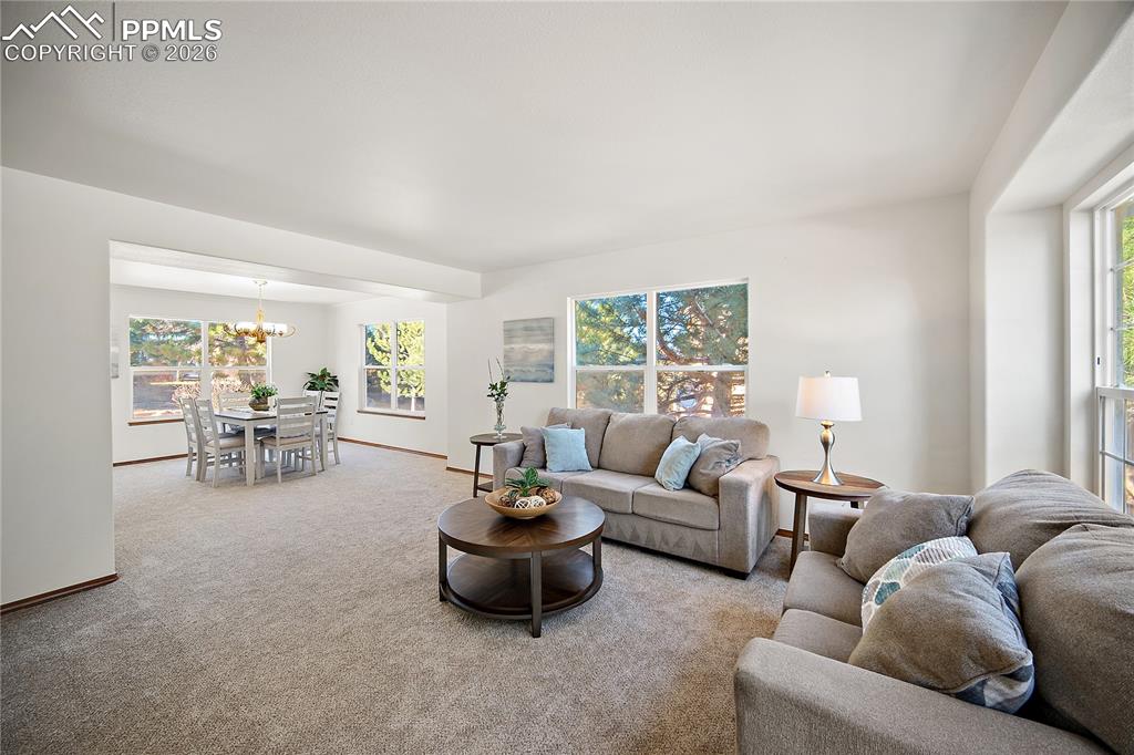 Image 5 of 44: Formal living and dining rooms are open and bright. Large windows flood the