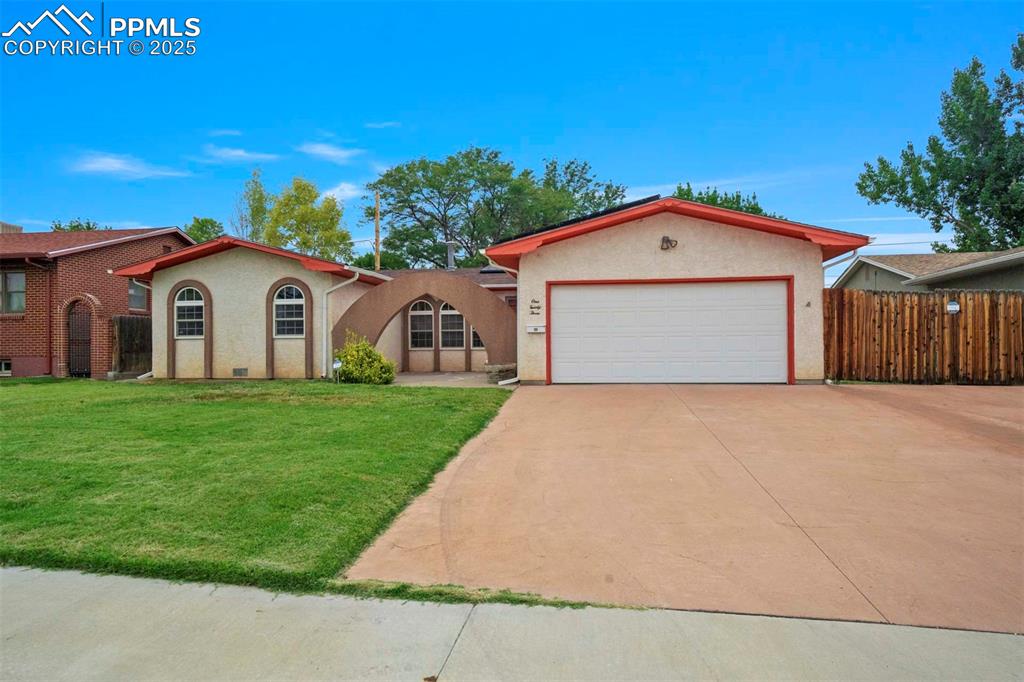 Caption: View of front of property with an attached garage, concrete driveway, and stucco siding