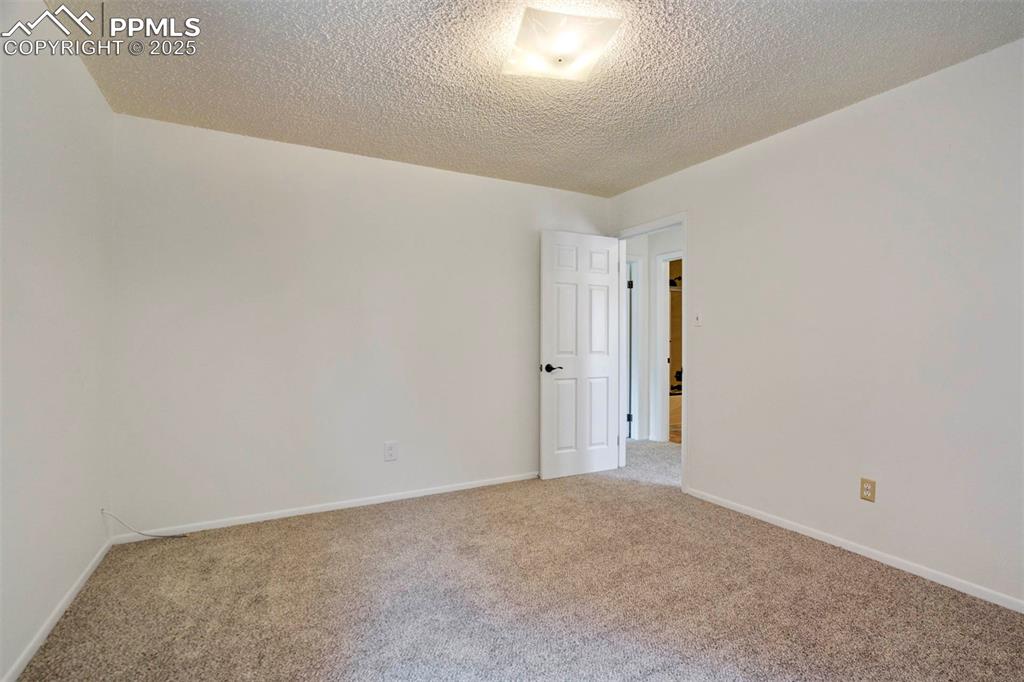 Image 26 of 45: Carpeted bedroom with baseboards and a textured ceiling
