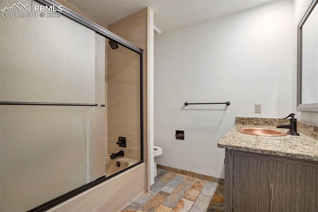 Image 28 of 45: Full bathroom featuring shower / bath combination with glass door, vanity, 