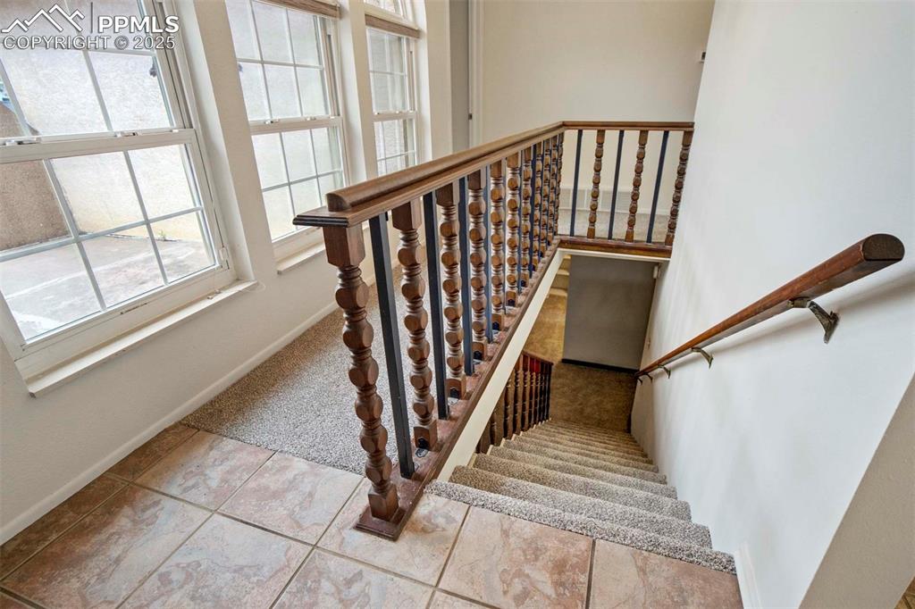Image 30 of 45: Stairway with carpet and tile patterned flooring