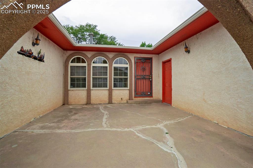 Image 4 of 45: Doorway to property featuring stucco siding and a courtyard area