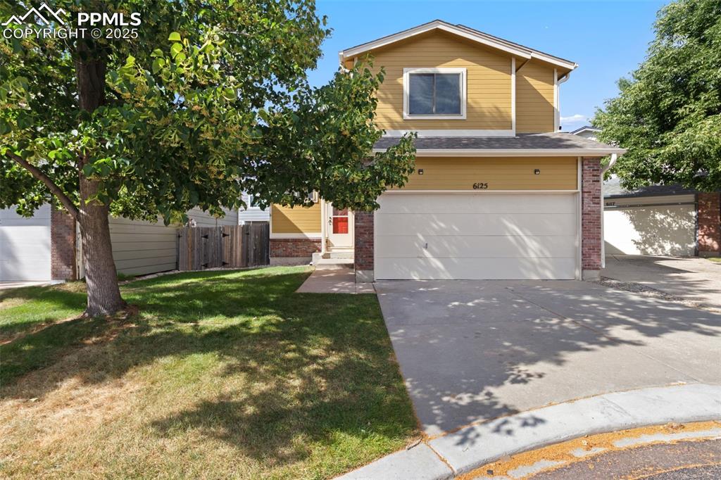 Caption: View of front of home featuring brick siding, a garage, concrete driveway, and entry steps