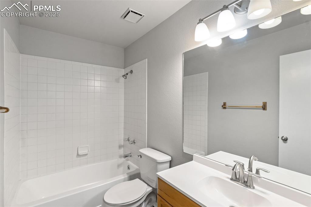 Image 11 of 31: Full bathroom with vanity, shower / bath combination, and a textured wall