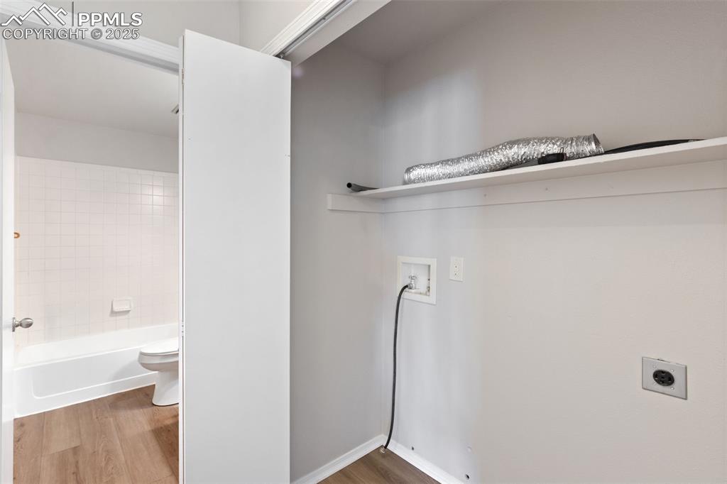 Image 12 of 31: Laundry room with electric dryer hookup, washer hookup, and wood finished f