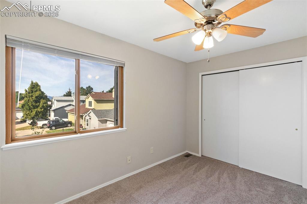 Image 19 of 31: Unfurnished bedroom with carpet flooring, a closet, and a ceiling fan