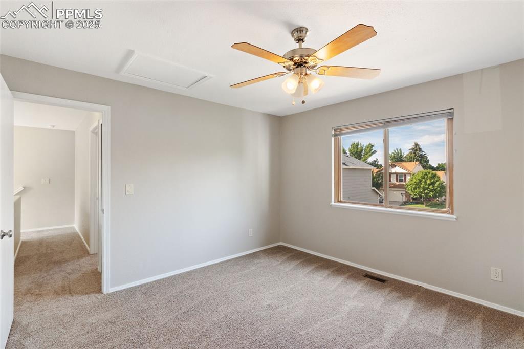 Image 21 of 31: Carpeted empty room featuring attic access and baseboards