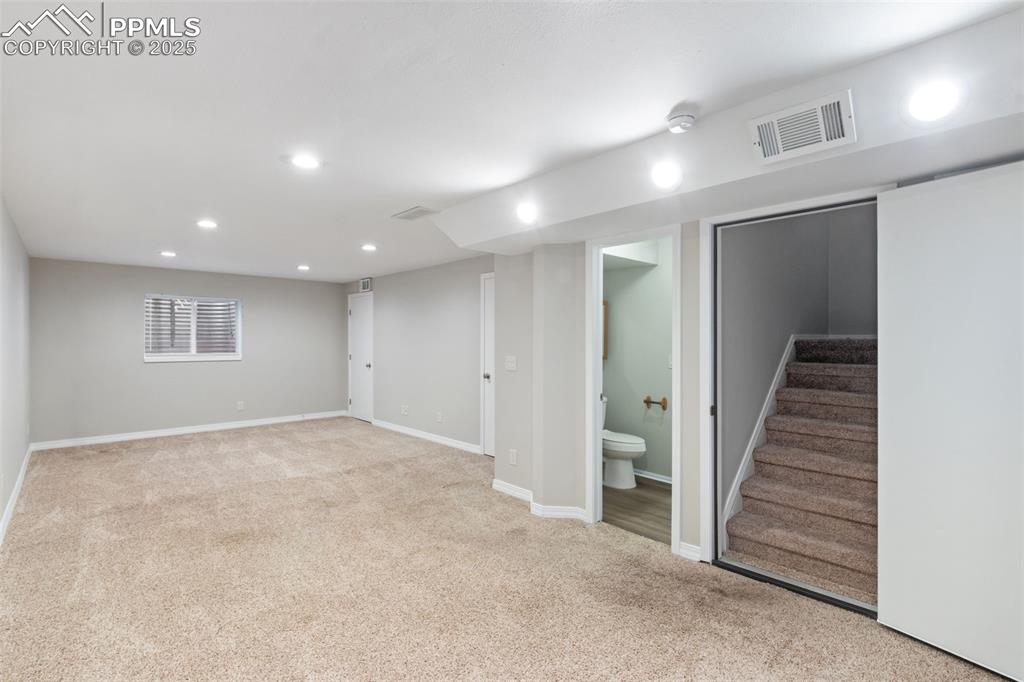Image 23 of 31: Finished basement with recessed lighting, carpet flooring, and stairs