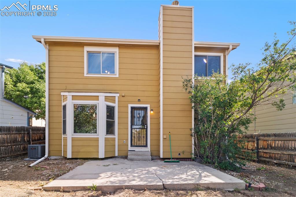 Image 27 of 31: Rear view of property featuring a patio, a chimney, a fenced backyard, and