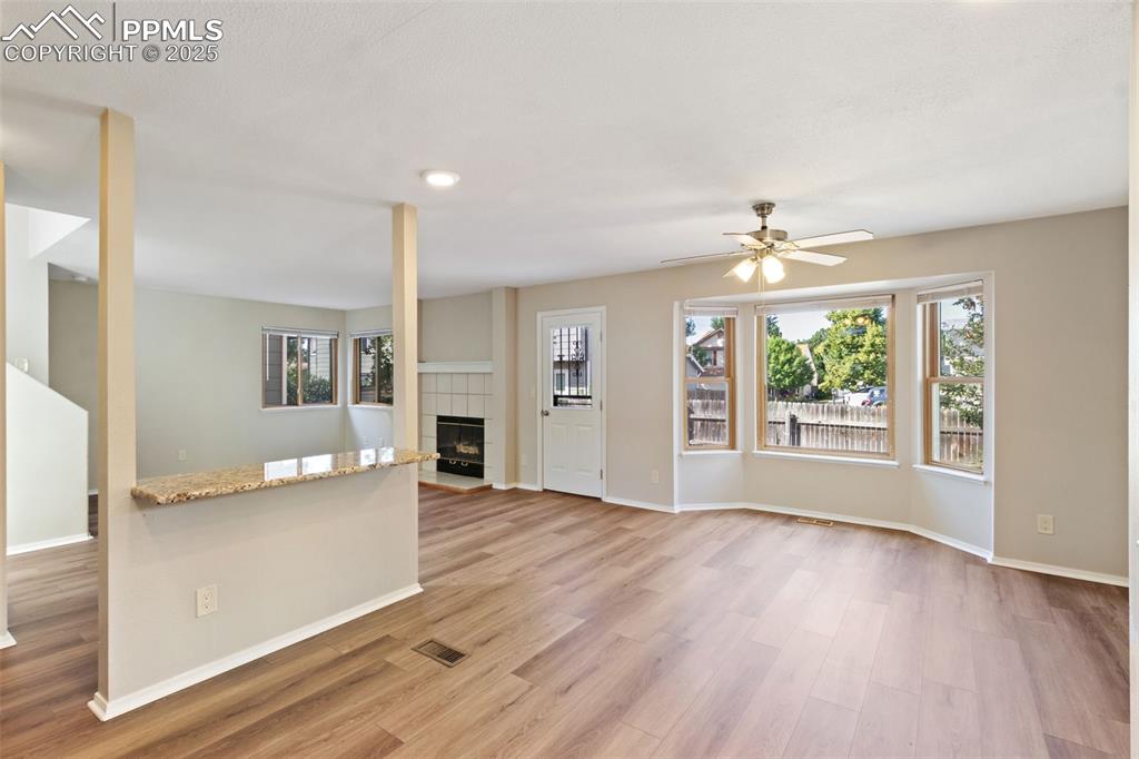 Image 5 of 31: Unfurnished living room featuring a tile fireplace, wood finished floors, a