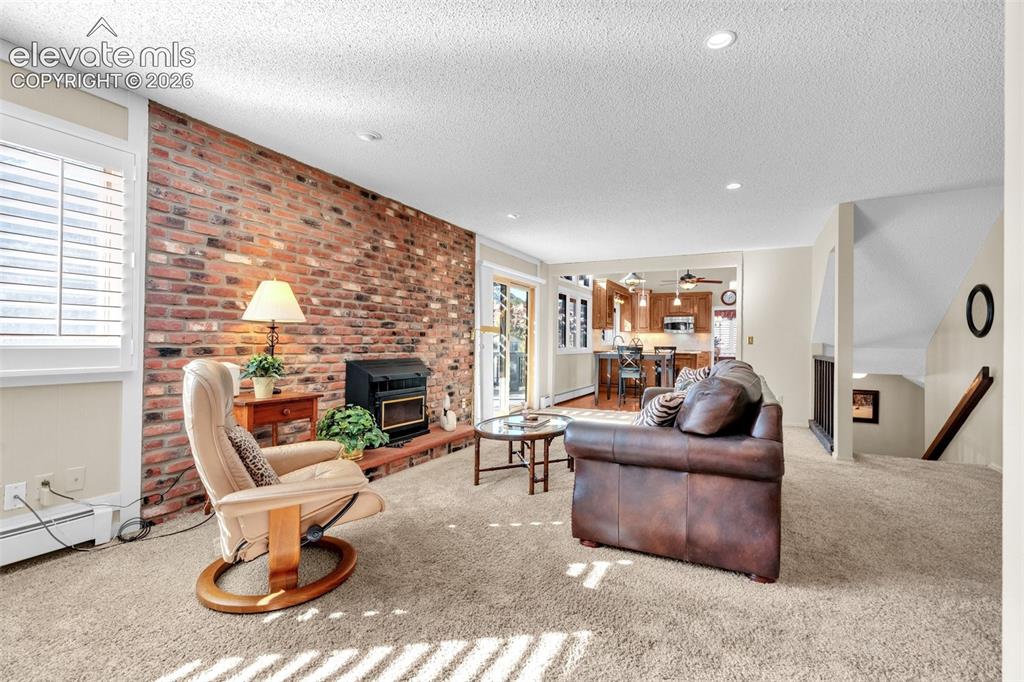 Image 38 of 50: Stunning brick wall with wood burning stove.