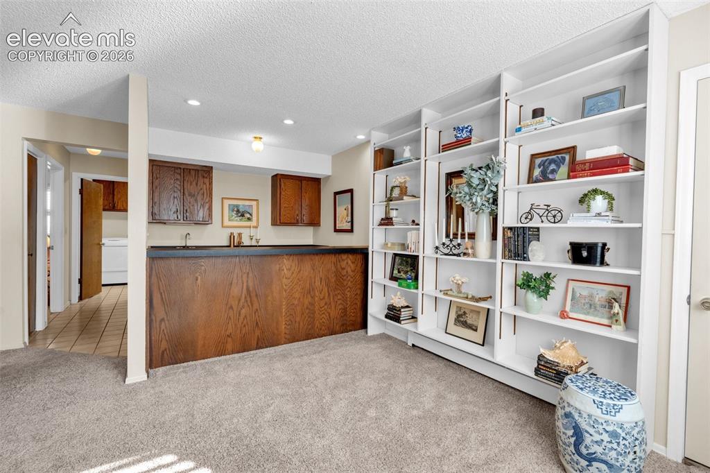 Image 39 of 50: Family room built-ins with wet bar.