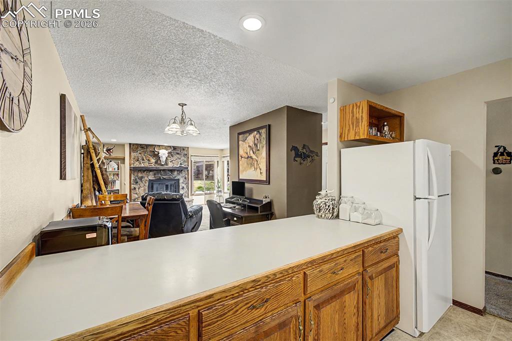 Image 12 of 23: The dining area sits warmly beneath a classic chandelier, tucked alongside 