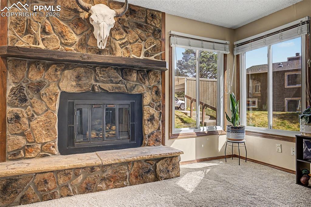 Image 5 of 23: The living room radiates warmth and personality — the stone hearth anchors 
