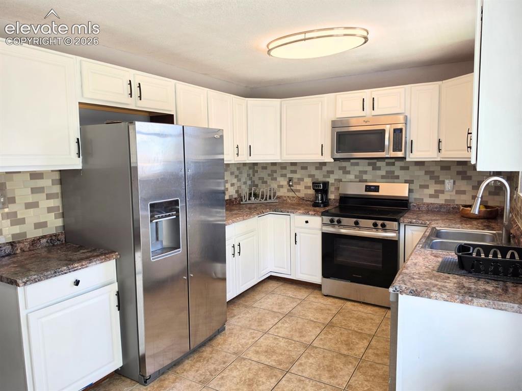 Image 8 of 18: Kitchen with stainless steel appliances, including a brand-new stove (2026)