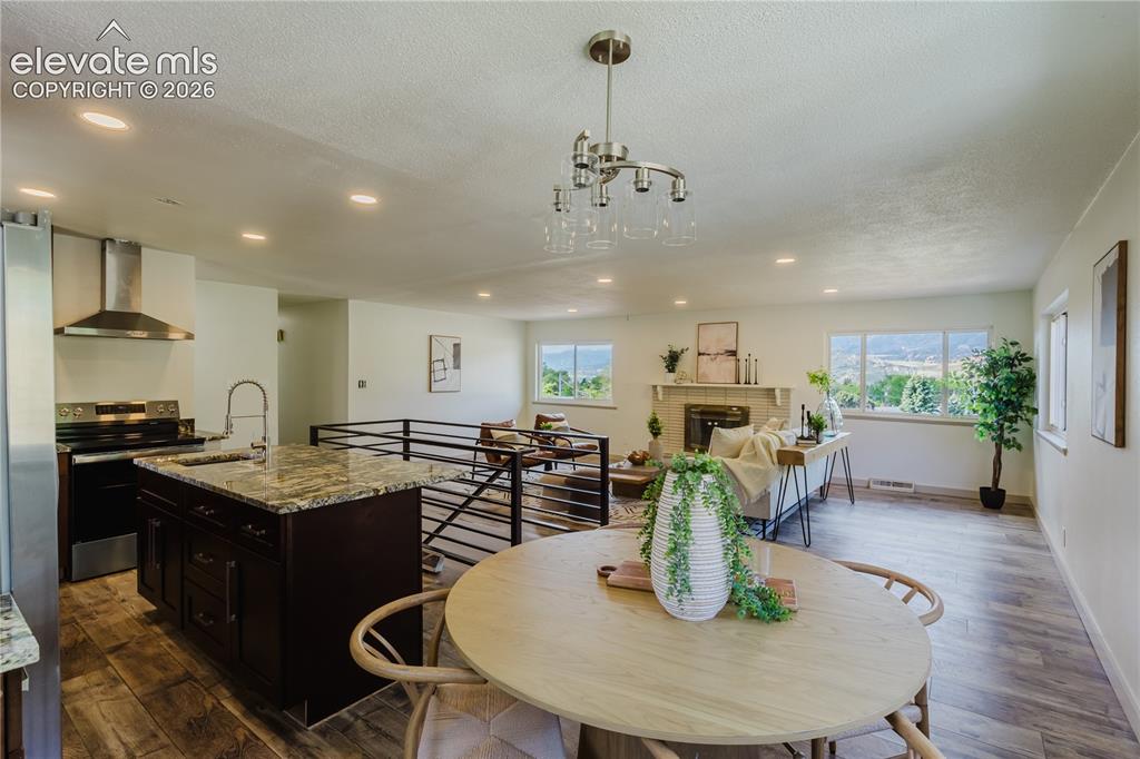 Image 12 of 47: Open-concept living space featuring wood-finish flooring, recessed lighting